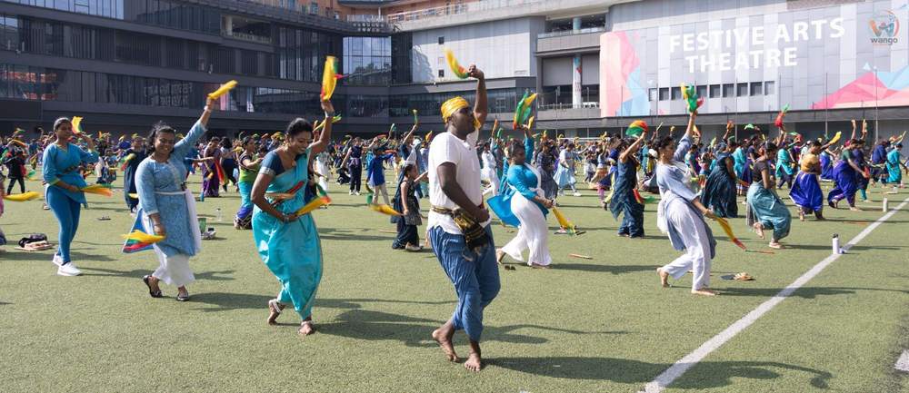 Oyilattam dancers in a row, a coloured scarf held in each hand